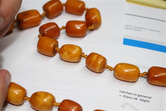 A single strand barrel shaped amber bead necklace, 86cm.